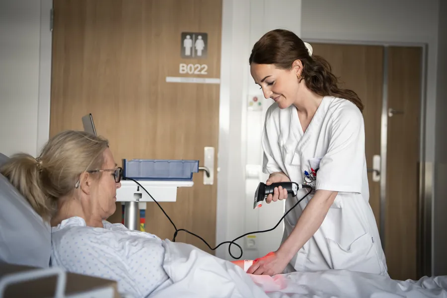 En lege som sjekker pasientens blodtrykk