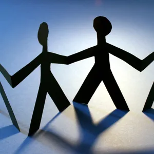 Pappfigur av mennesker hånd i hånd