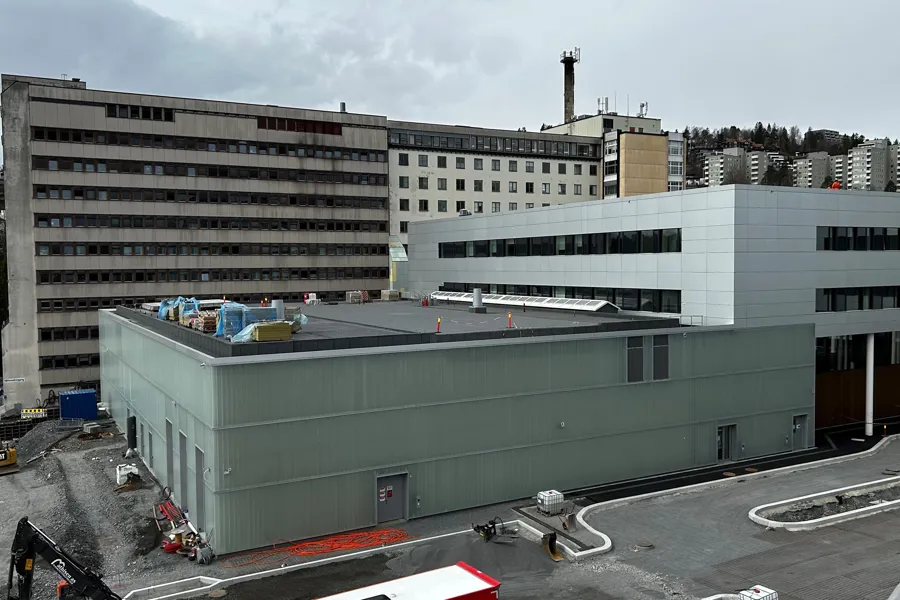 En stor bygning med en stor betongvegg foran seg