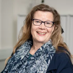 En person med langt hår smilende