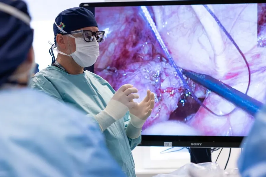 En mann i maske som ser på en skjerm