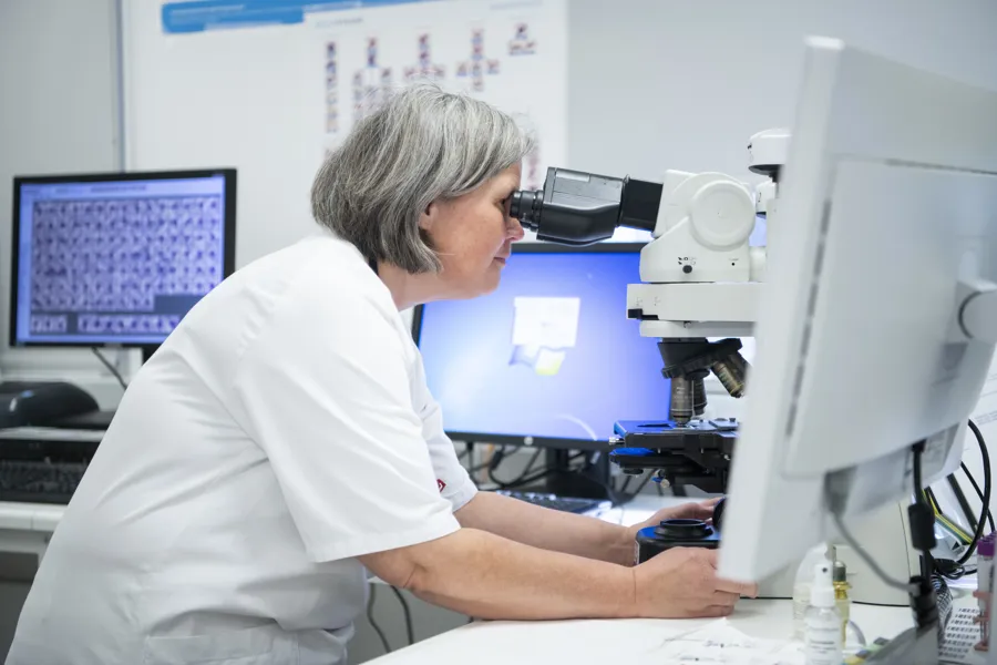 Illustrasjonsbilde kvinne ser i mikroskop