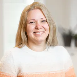 En kvinne som smiler til kameraet