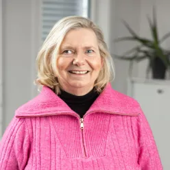 En kvinne som smiler til kameraet