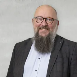 En mann med skjegg og briller