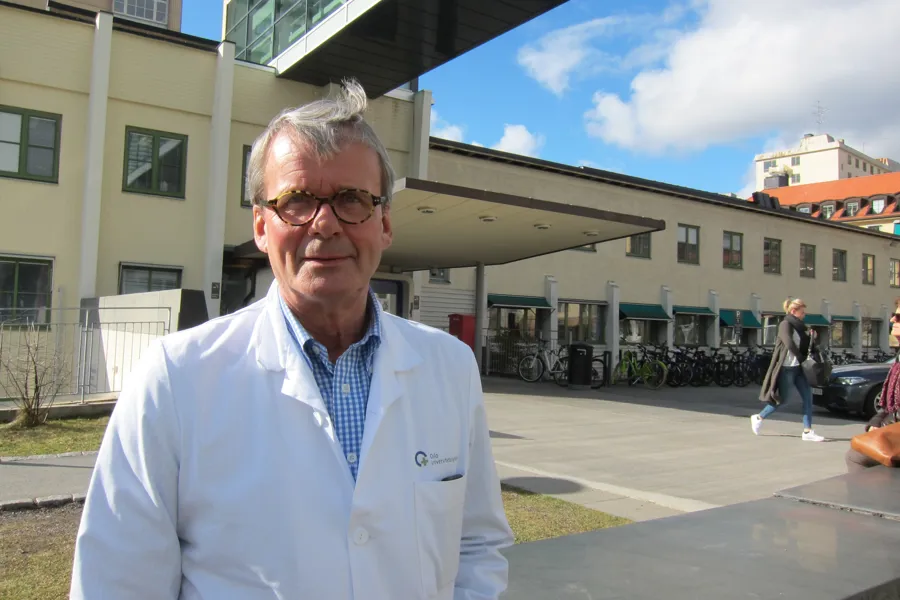 En mann iført hvit frakk